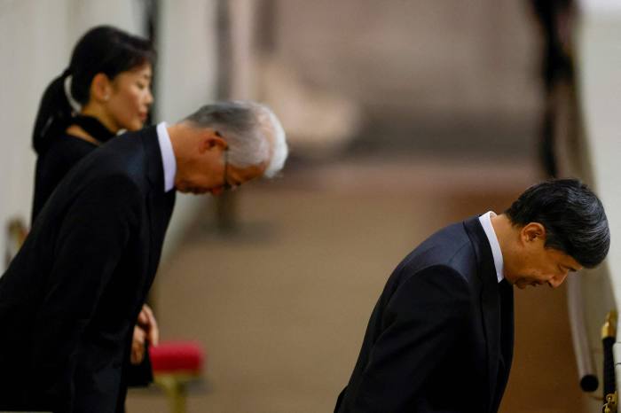 Emperor Naruhito of Japan, right, (R) pays his respects at the coffin of Queen Elizabeth II lying in state inside Westminster Hall