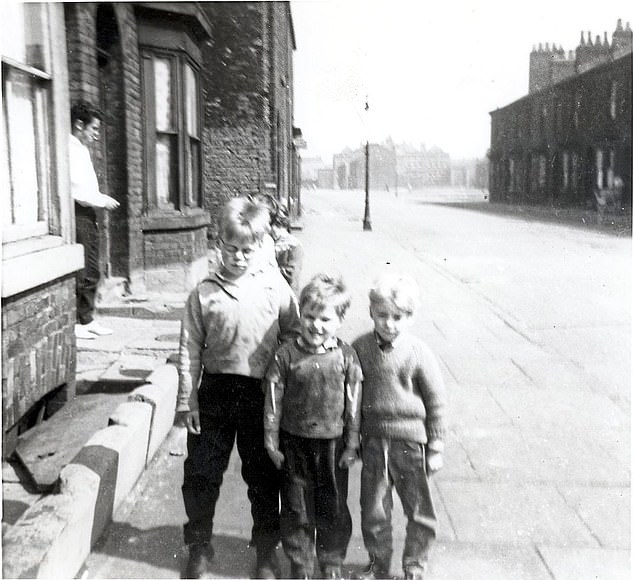 Keith, pictured left with two young boys in Manchester. His brother Alan shared a bedroom with him on Eston Street, which is in the Longsight district of Manchester