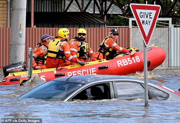 Rescue workers (pictured) use an inflatable dinghy to rescue people from floodwaters in Maribyrnong