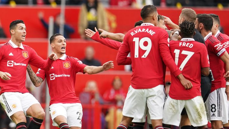 Manchester United players surround referee Craig Pawson