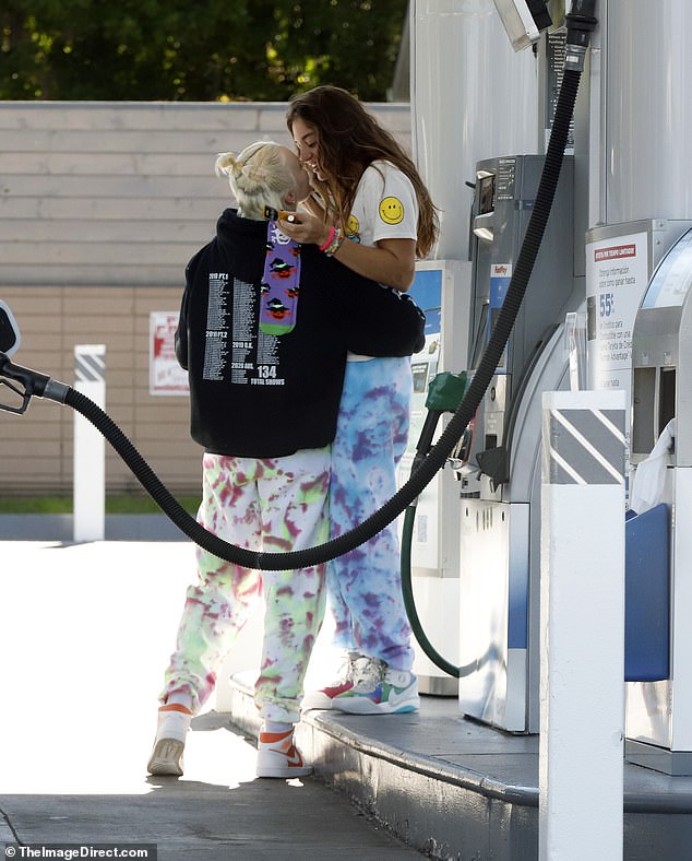 Pucker up! The couple packed on the PDA as they waited for the tank to fill up