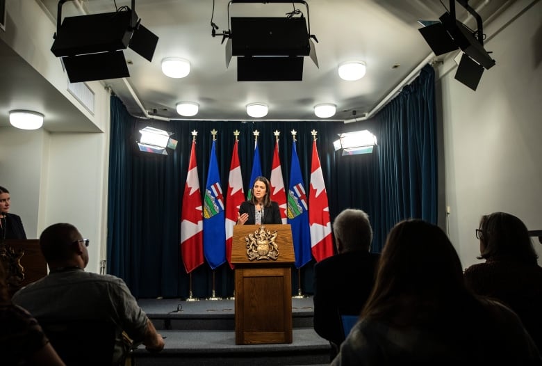 A woman stands behind a podium.