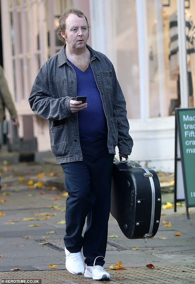 Chilled: The 44-year-old dressed down in a dark grey denim jacket and carried a guitar case for his low-key outing