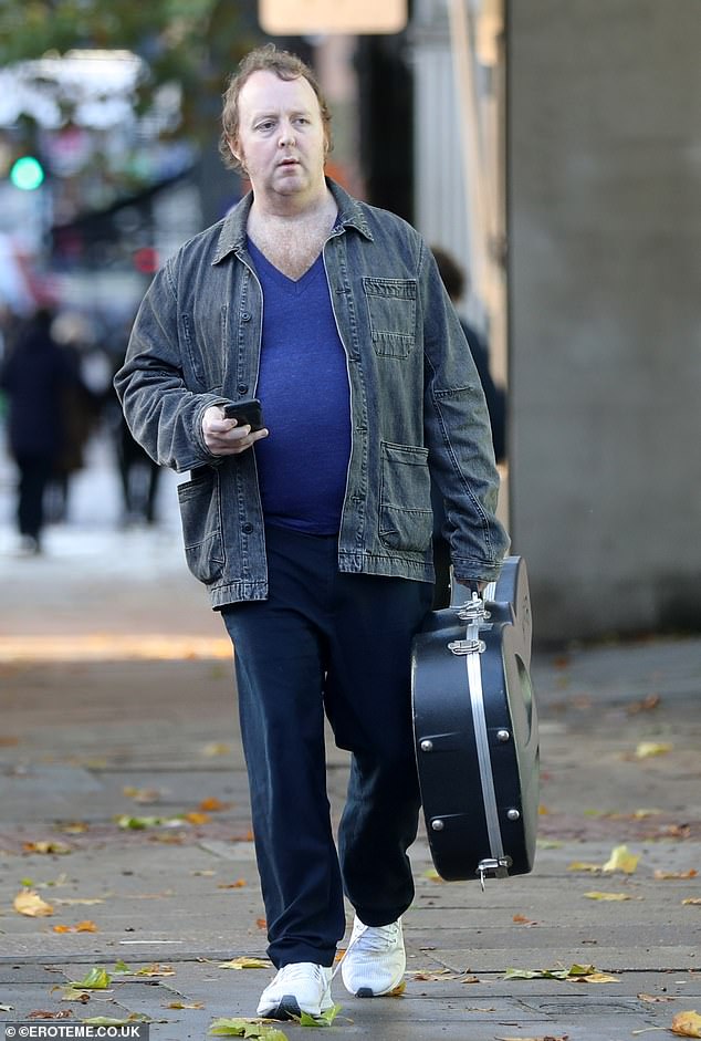 Guitar: James looked happy and relaxed as he headed out before sitting at an outdoor café table where he chatted to a pal