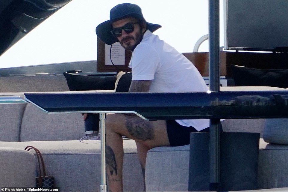 Stylish: Keeping his head cool, the sportstar rocked a blue fisherman's hat and classic black sunglasses