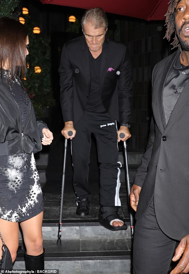 Hopping along: The star cut a smart figure on top in a black blazer which he teamed with a V-neck T-shirt as he made his way down a set of stairs