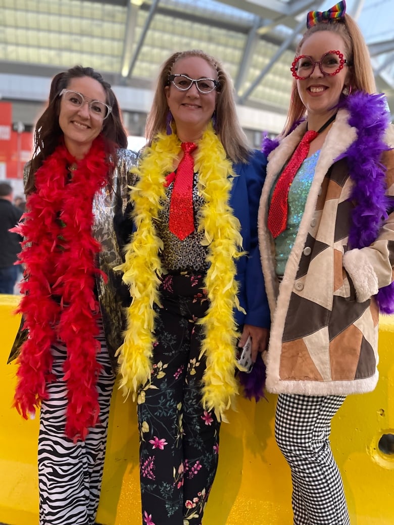 Three women dressed with feather boas.