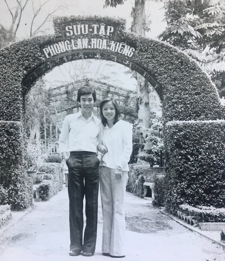 A man and a woman in front of an arch.