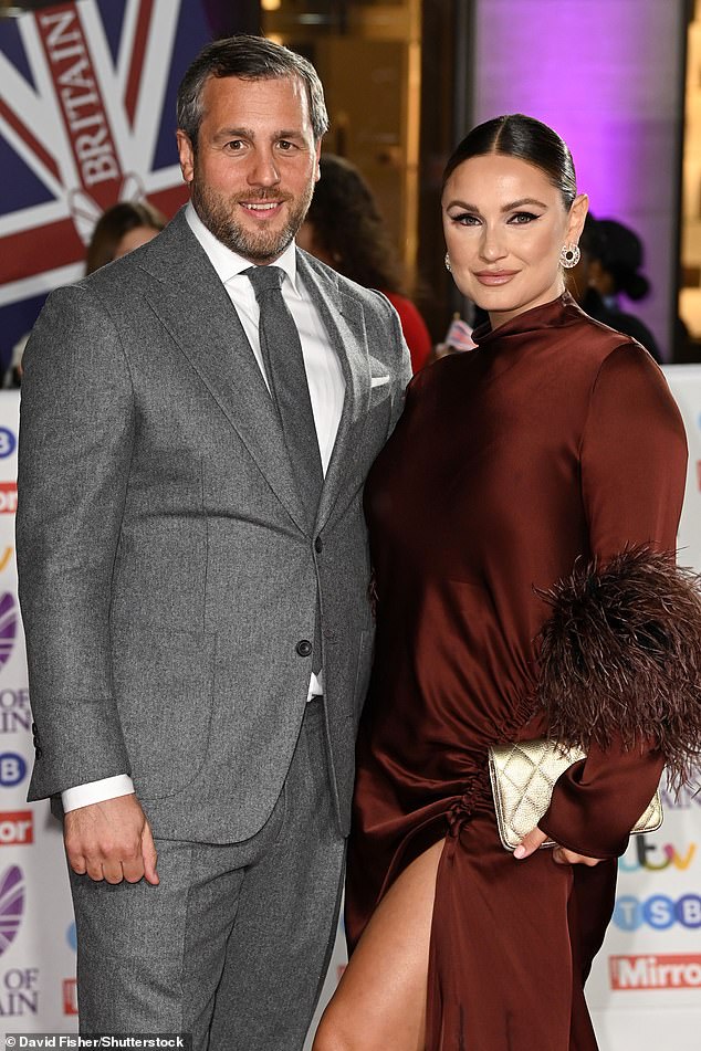 Elegant: Sam meanwhile, walked the red carpet with her husband Paul Knightley, stunning in an elegant brown dress that featured feather detailing on the sleeves and a thigh-split