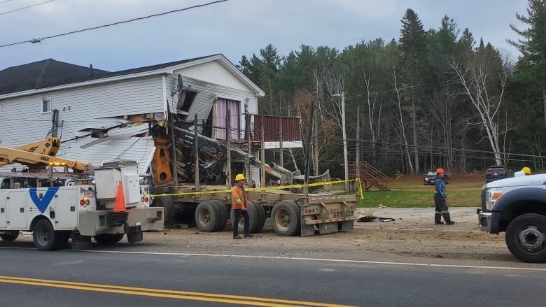 The back half of a transport trailer protrudes from the side of a building.