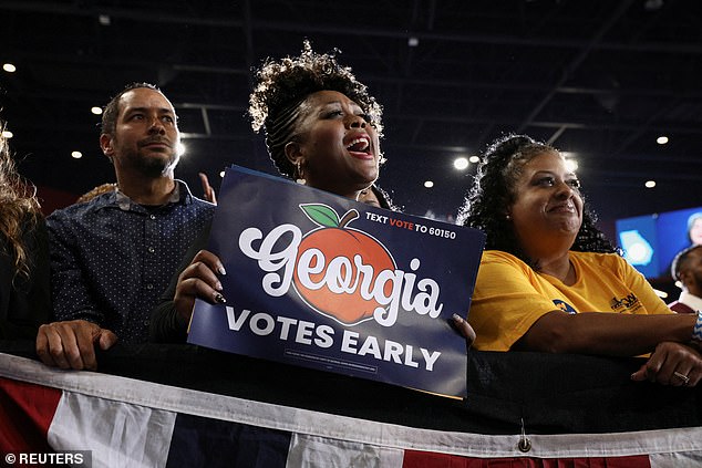 A woman holds up a sign encouraging Georgians to vote early at Friday night's rally outside of Atlanta in support of Democrats