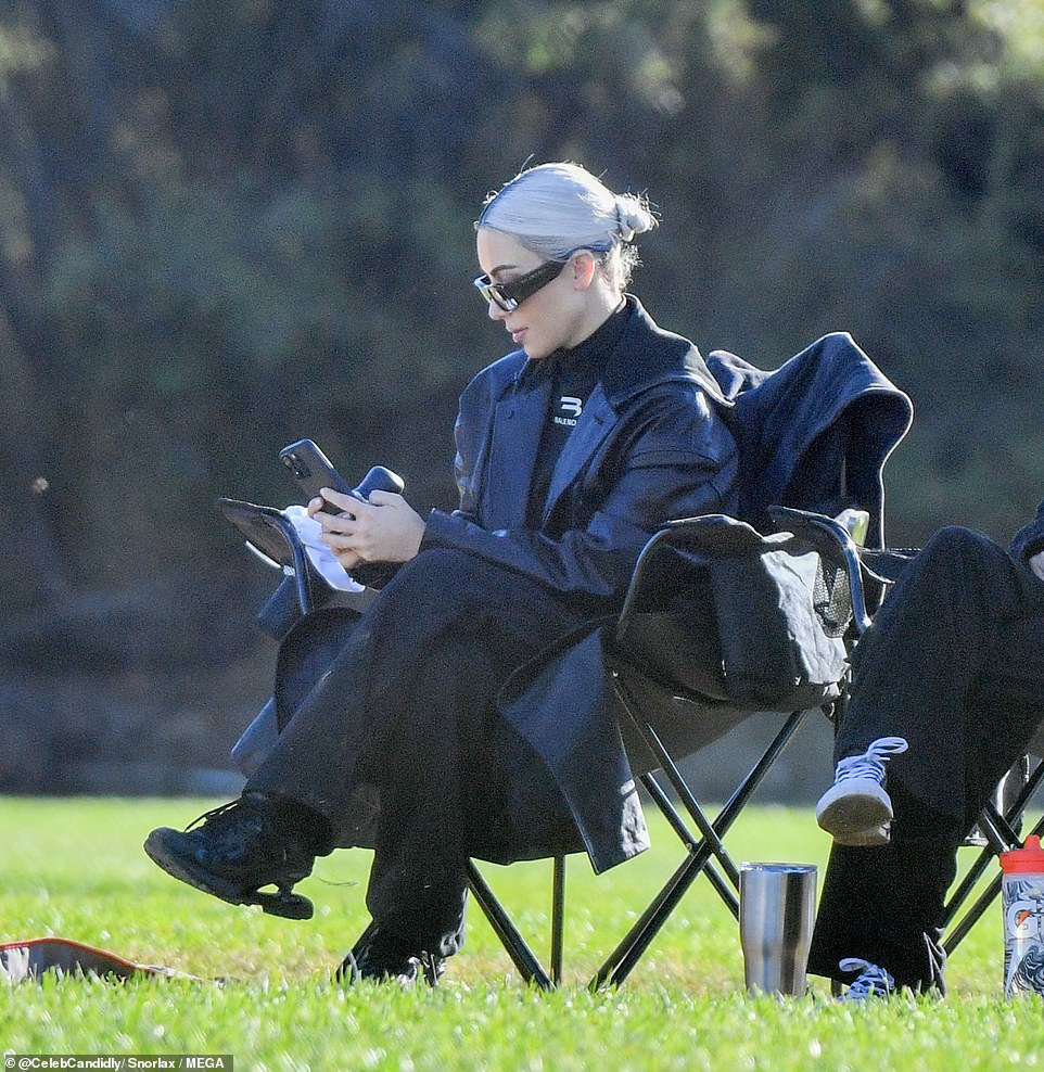 Multitasking: The busy businesswoman took a moment during the game to glance over her iPhone