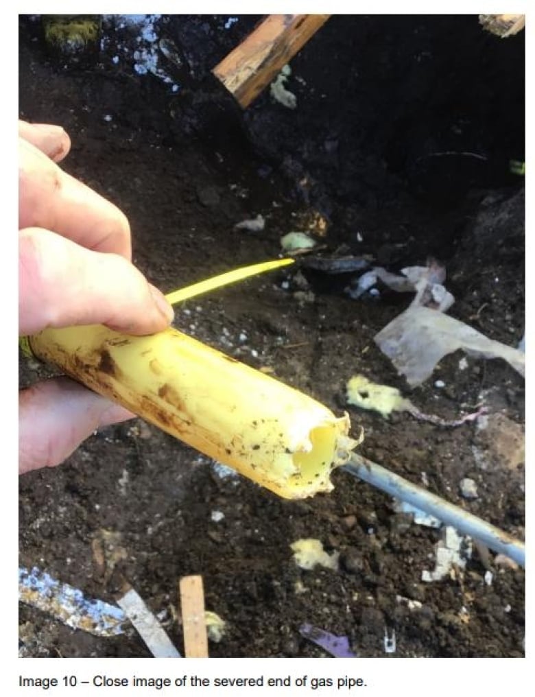 An image showing a person holding up a severed section of a yellow pipe.