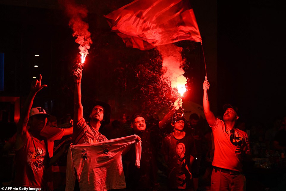 Supporters of Luiz Inacio Lula da Silva light flares during the vote count of the presidential run-off election at the Paulista avenue in Sao Paulo, Brazil