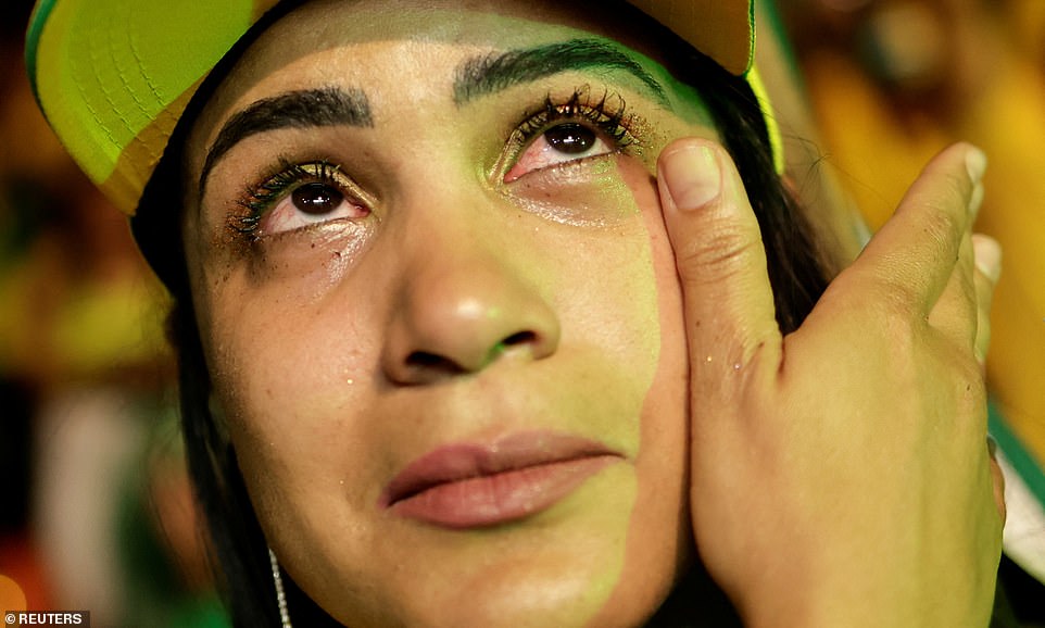 A supporter of Brazil's President and presidential candidate Jair Bolsonaro wipes her face during the Brazilian presidential election run-off, in Brasilia, Brazil