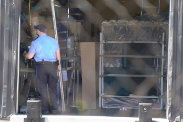 A police officer is seen inside a warehouse.