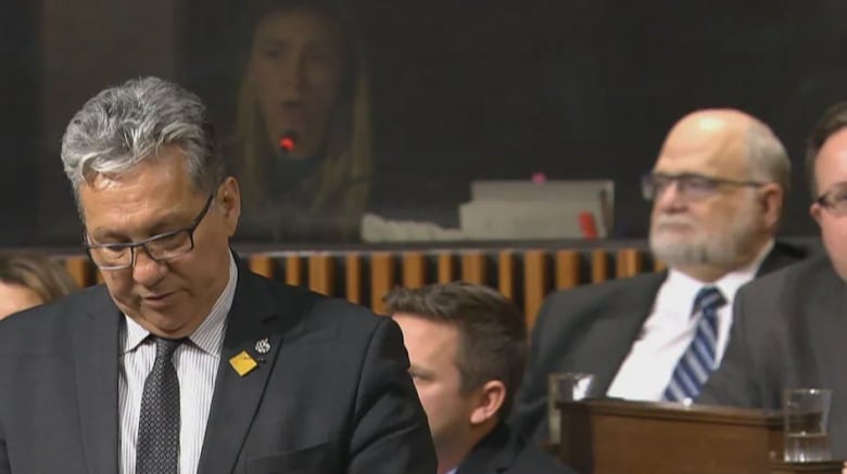 A federal interpreter, tasked with translating English to French and vice versa, is seen in the background of this photo of a House of Commons debate.