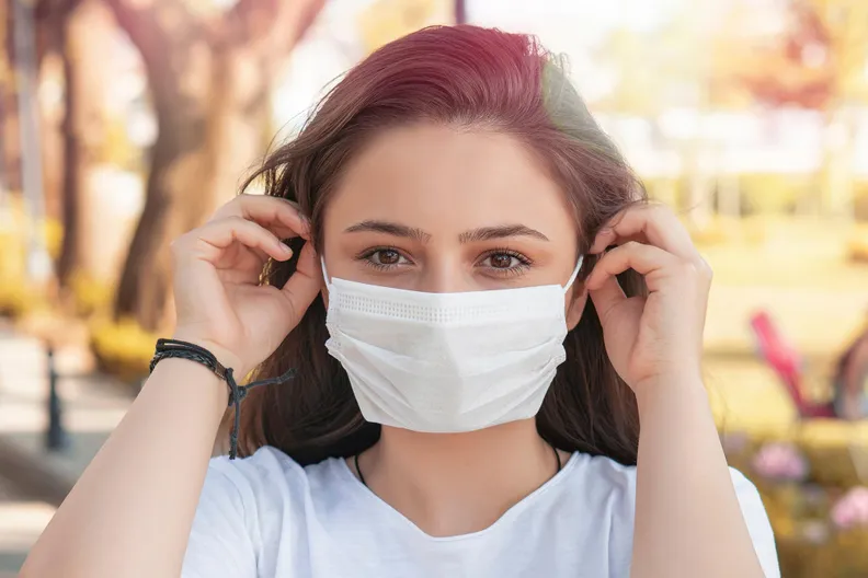 Woman Putting on COVID Face Mask