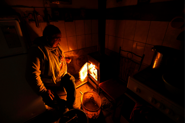 Zoltán Berki puts wood on the fire to warm up his home in Ózd, northern Hungary  