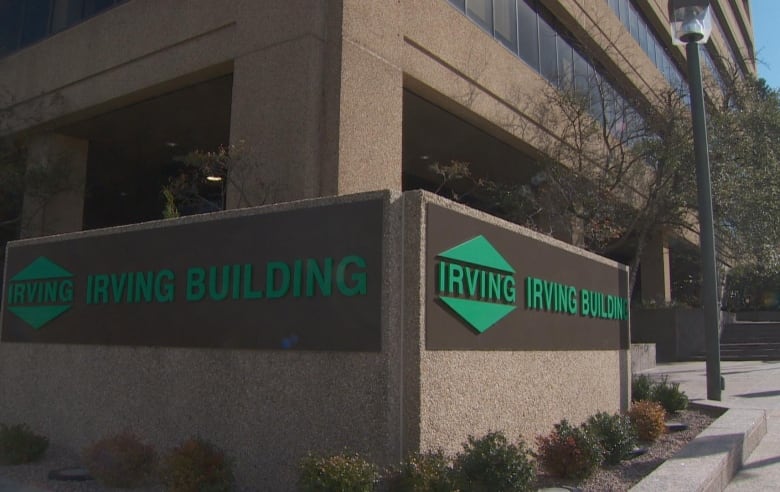 A brown brick office building features green lettering in the front that says Irving Building. The design also includes the Irving logo. 