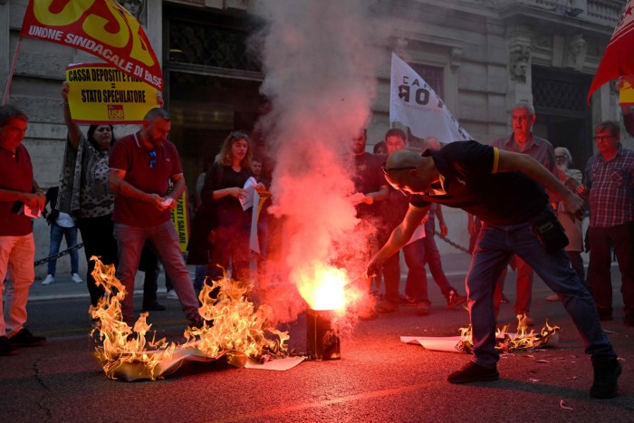 Protesters burn their energy bills in Rome. Italy’s tax on energy companies only brought in an estimated $2bn, far below expectations