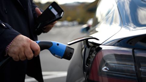 A customer prepares to charge a Tesla electric car at a supermarket in north London. 