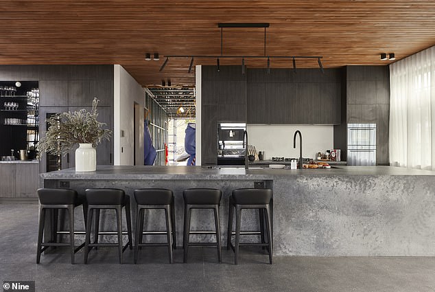 A Caesar stone waterfall benchtop and splash back, wine fridge, and serving bar are all spectacular features in the kitchen (pictured)