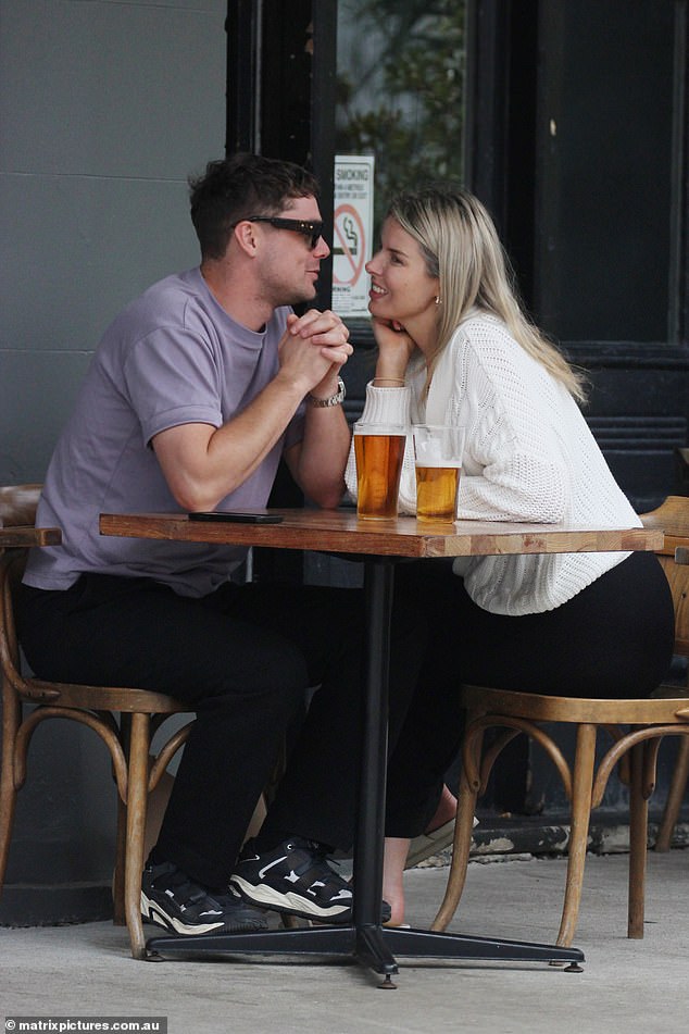 Olivia looked stylish for the outing in black pants, a white jumper and a pair of white sandals