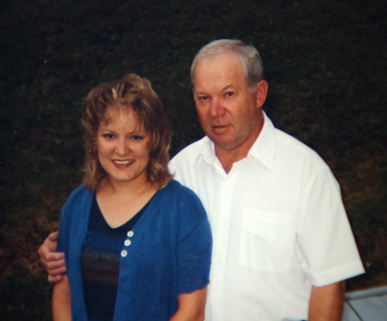 A young woman, left, and a middle-aged man smile into the camera. He has his arm around her. Clothes and hairstyles indicate the photo was taken xx ago.