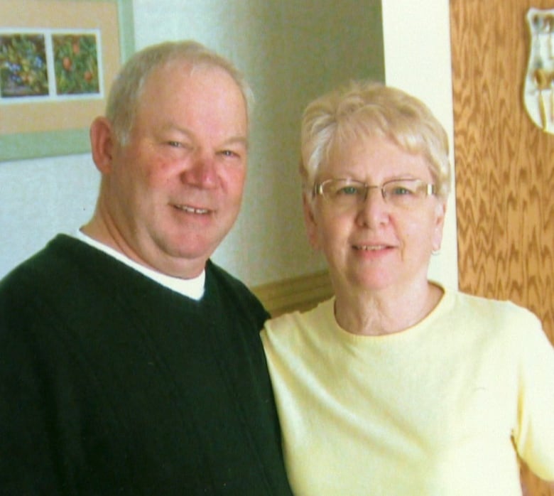 An older man, left, and woman smile into the camera.