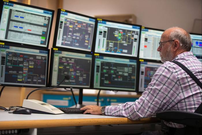 An Evonik employee looks at a bank of computer monitors