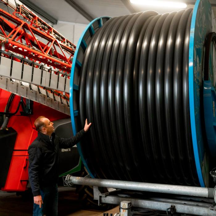 Hendrik Jan ten Cate looks up at a huge reel of irrigation piping