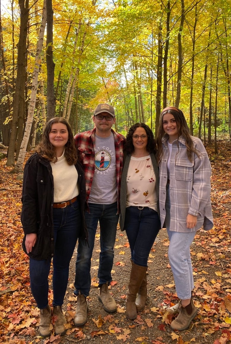 A family photo in front of fall leaves.