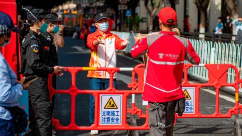 A delivery worker delivers a package to the entrance of a locked-down neighborhood in Liwan, Guangzhou, on November 9.