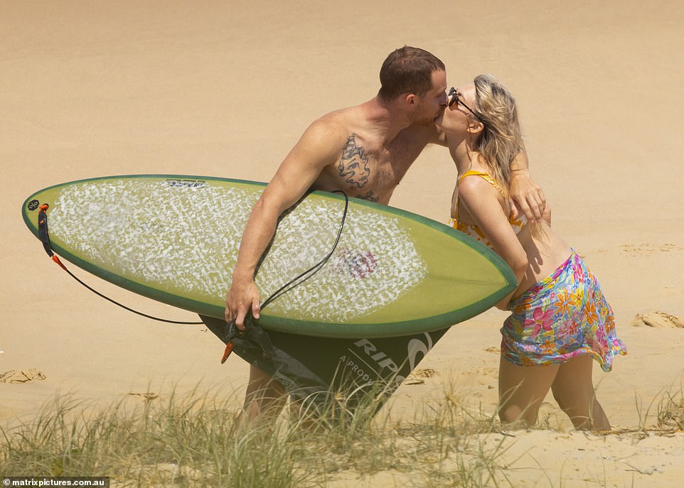 As he returned to the shore, the couple shared a loving kiss on the sand