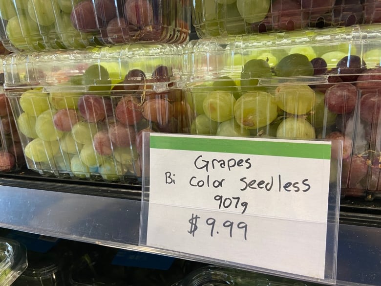 A handwritten sign shows the price of seedless grapes.