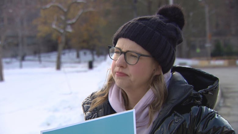 Bronwen Alsop wear glasses and a toque in front of a snowy background. 