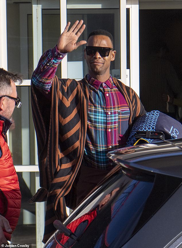 Looking good: Johannes Radebe donned a colourful shirt and orange poncho as he waved to onlookers