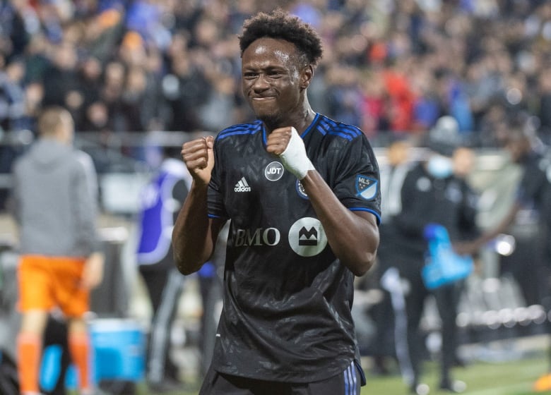 Ismael Koné smiles after goal with hands.