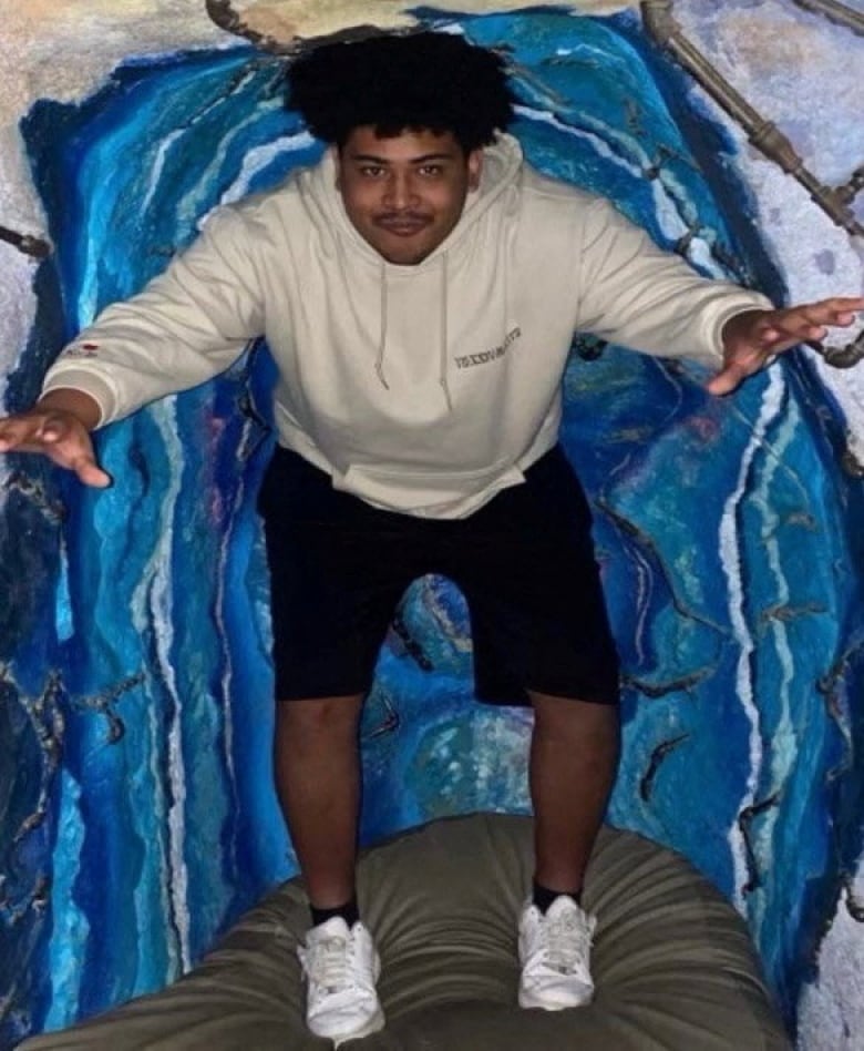 A man poses for the camera in what appears to be a low tunnel with a padded floor.