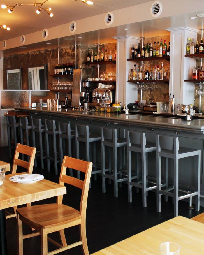 The bar at Houseman, with tables and chairs in the foreground