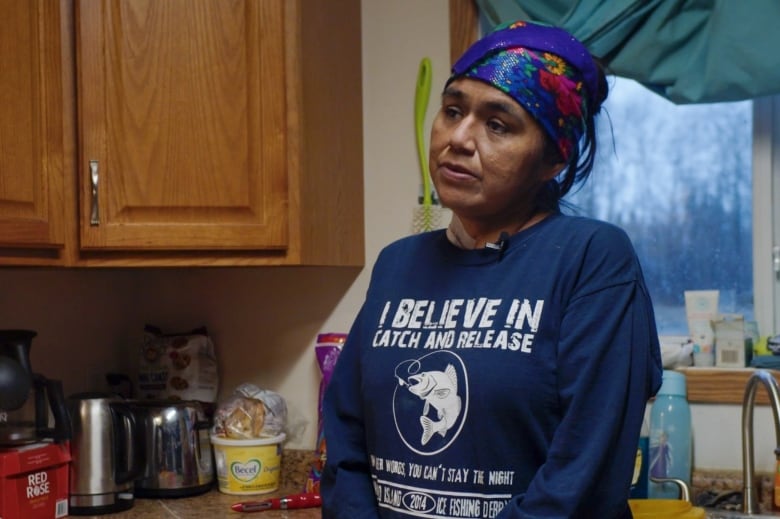 A photo of a woman standing in a kitchen.