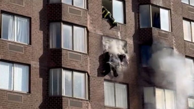 Firefighters rescue woman dangling from 20th-story window