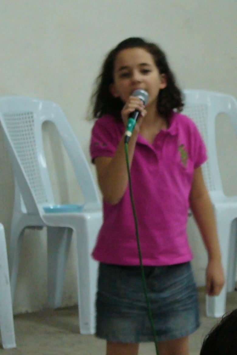 A girl holds a mic.  