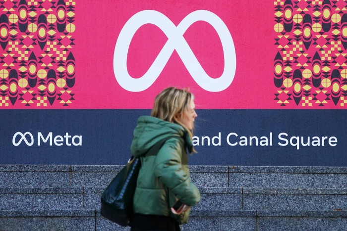 Person walks past Meta sign outside office in Dublin