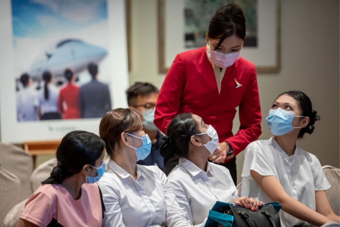 A staff member speaks with applicants during a Cathay Pacific flight attendant recruitment event