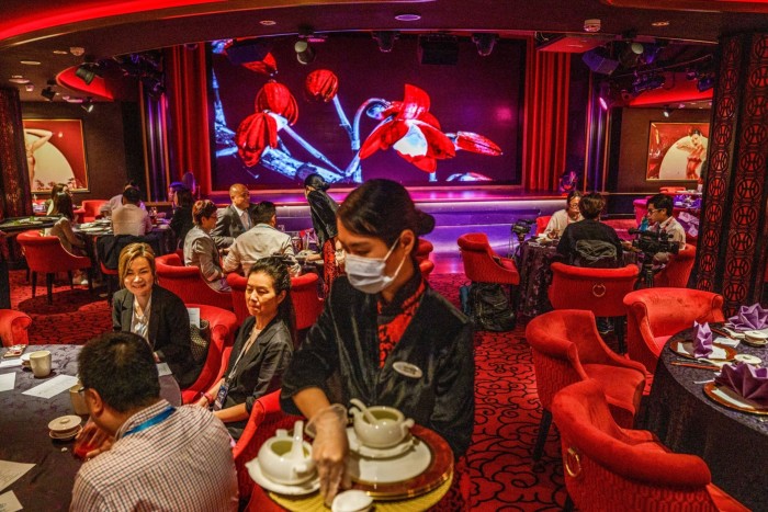 A waitress serves passengers on the Genting Dream cruise ship