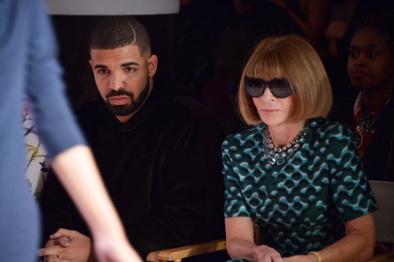 Drake and Anna Wintour sit in the front row of a runway fashion show. 