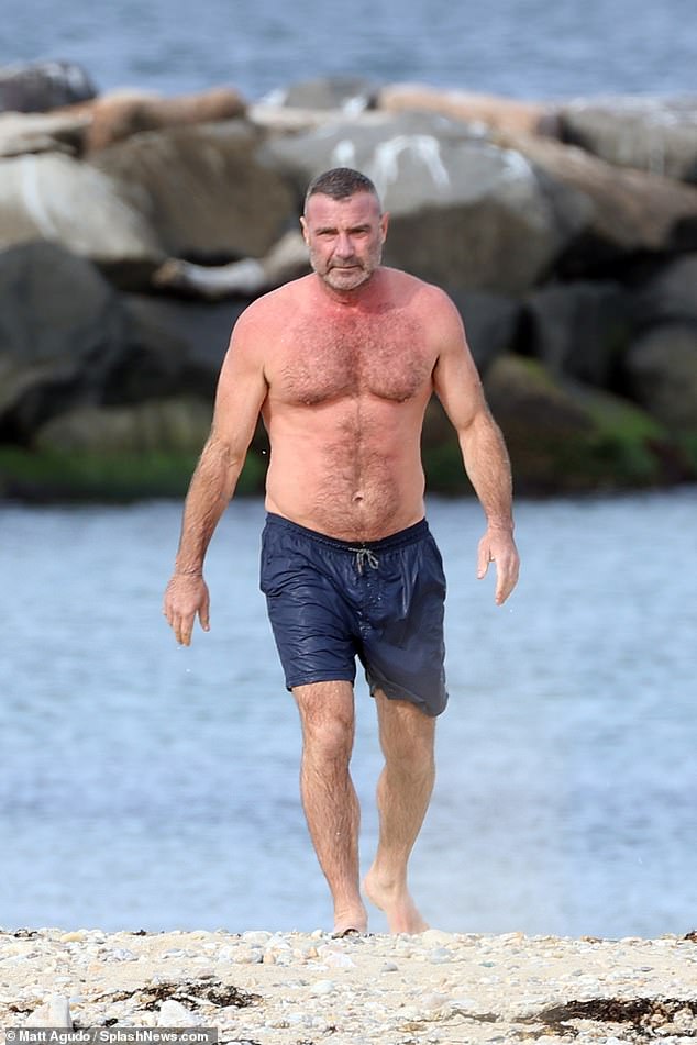 Liev Schreiber, 55, showcases his 6ft3in form while taking a dip in the ocean in the Hamptons