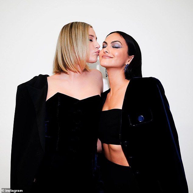 Lili Reinhart affectionately plants a kiss on Camila Mendes’ cheek while posing for photos